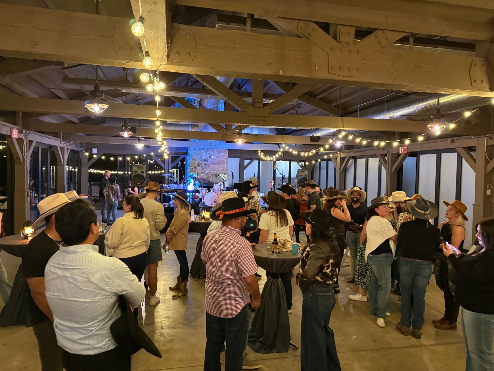Guests dancing in custom cowboy hats at barn venue