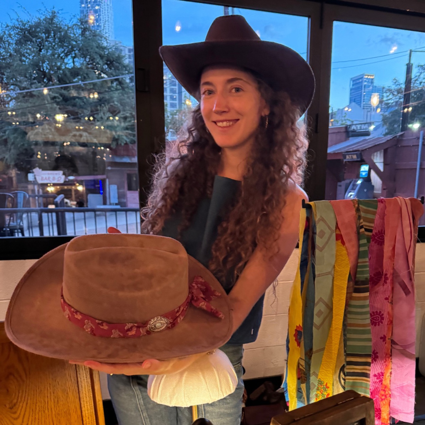 Stylist holding a finished custom hat at Red's Western